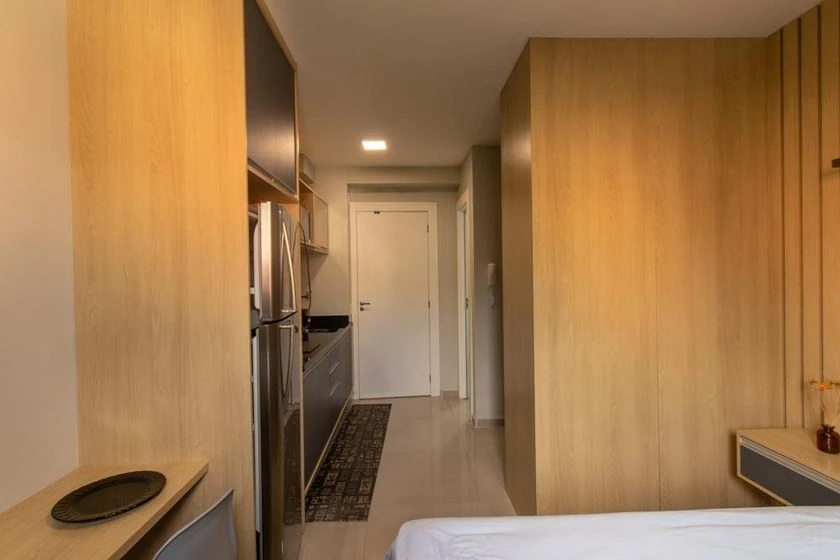 Furnished studio with a compact kitchenette and desk area — photo 10