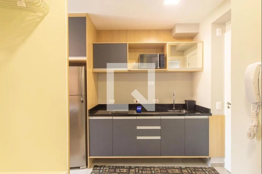 Furnished studio with a compact kitchenette and desk area — photo 6