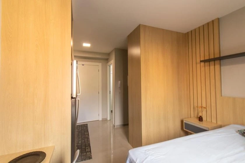 Furnished studio with a compact kitchenette and desk area — photo 9