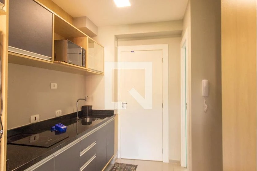 Furnished studio with a compact kitchenette and desk area — photo 2