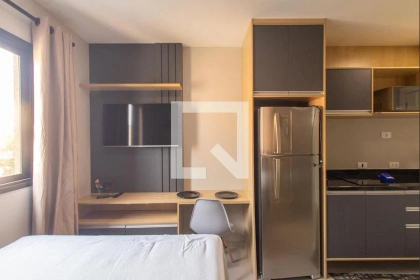 Furnished studio with a compact kitchenette and desk area — photo 3