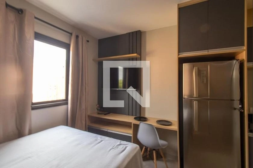 Furnished studio with a compact kitchenette and desk area