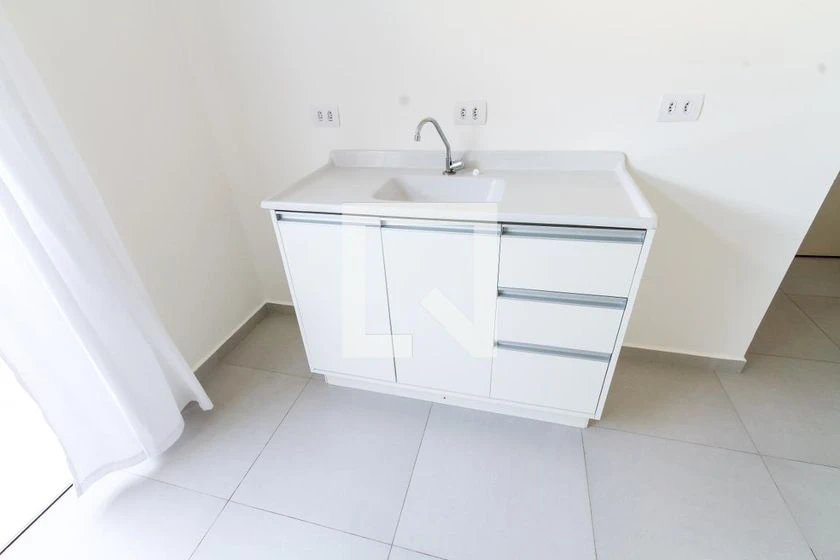 Kitnet mobiliada com cozinha compacta e quintal privativo