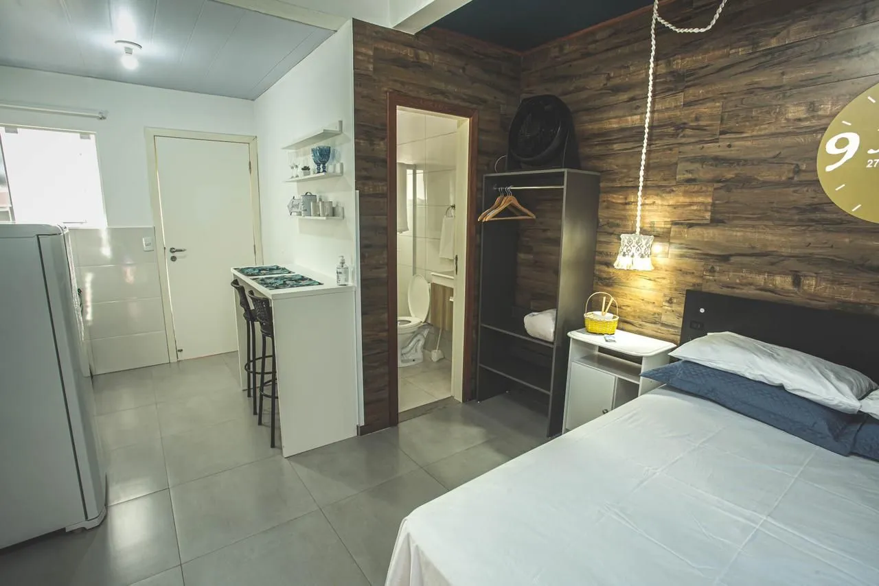 Studio kitnet with glass-enclosed shower and compact cooktop