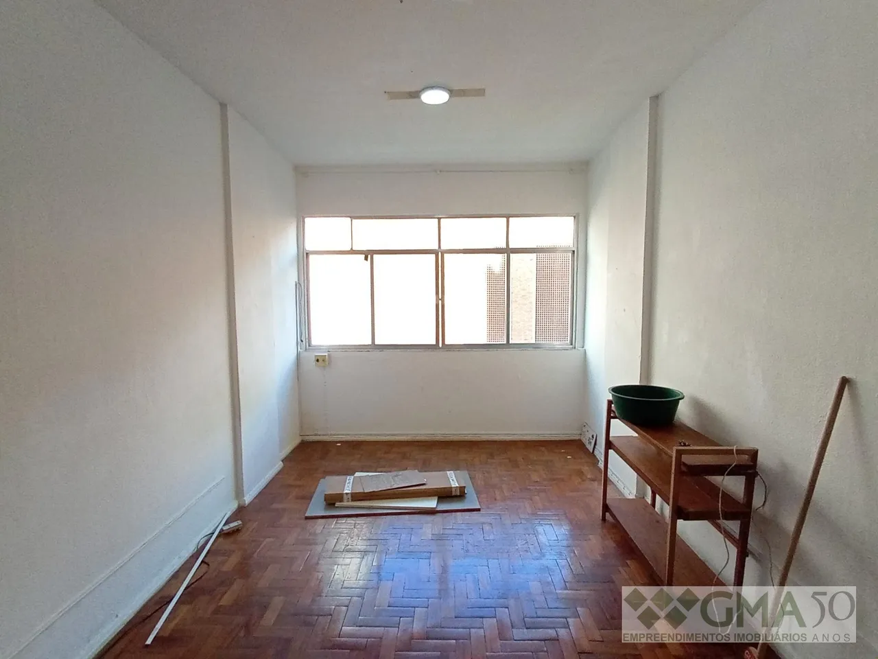 Unfurnished studio with a compact kitchenette and built-ins