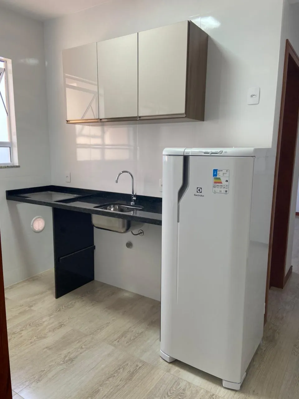 Unfurnished studio with kitchenette corner and glass shower