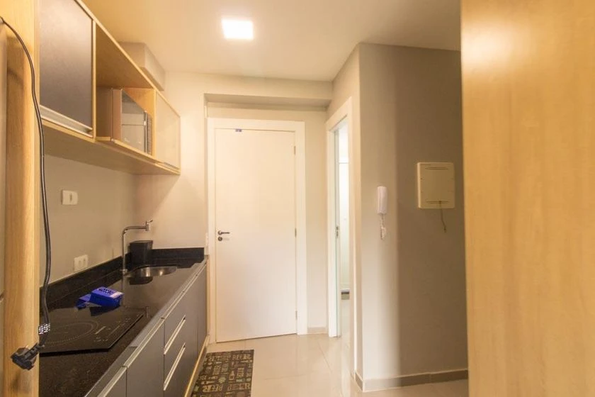 Furnished studio with a compact kitchenette and desk area — photo 4