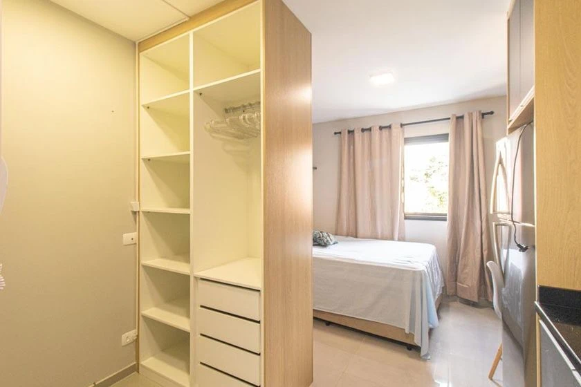 Furnished studio with a compact kitchenette and desk area — photo 5